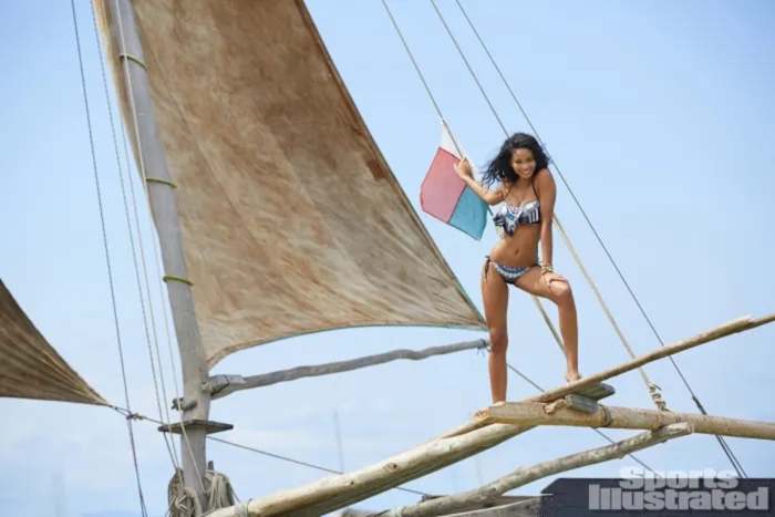 Chanel Iman stands on the wooden beams of a boat and poses in a black and white bikini.